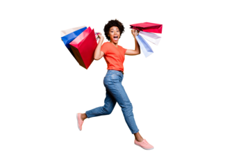 Full body photo of positive amazed cheerful funky wavy brown hair hold bags enjoy bargains boutique jump wear stylish trendy red t-shirt denim jeans sneakers isolated over yellow color background