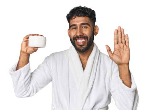 Hispanic male with moisturizer in studio smiling cheerful showing number five with fingers.
