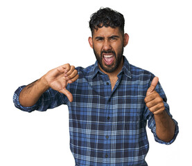 Young Hispanic man isolated showing thumbs up and thumbs down, difficult choose concept