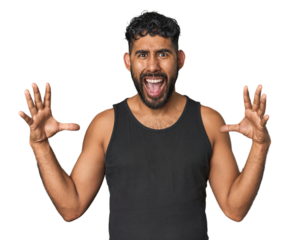 Young Hispanic man isolated screaming to the sky, looking up, frustrated.