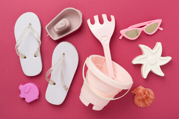 Children's flip flops and beach toys on color background,,top view