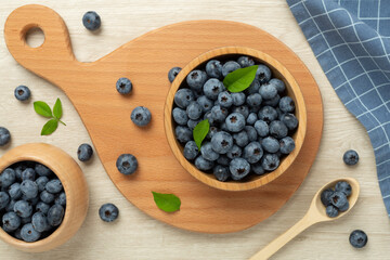 Bowl with fresh bright blueberries on wooden background,top view