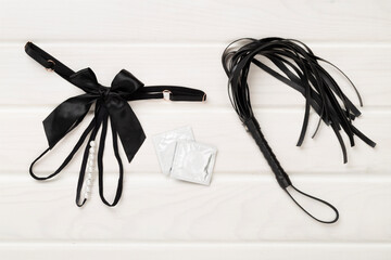 Set of erotic BDSM accessories on wooden background, top view