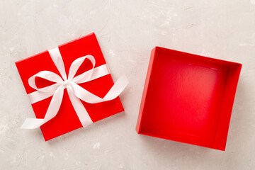 Open red gift box on concrete background, top view