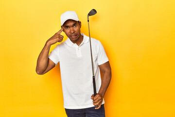 African American man golfer, yellow studio backdrop, showing a disappointment gesture with...