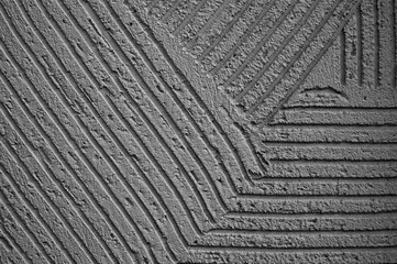 gray background, photo shows texture of decorative plaster on concrete wall close-up