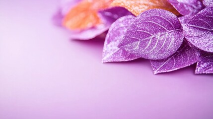Sparkling glitter leaves in shades of purple and orange are creatively placed on a soft pastel purple surface, perfect for celebration