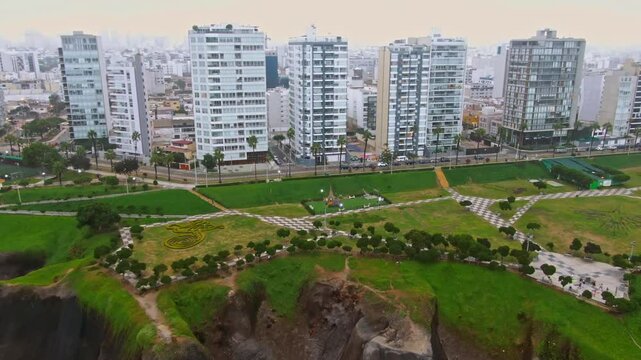 Dolly out drone shot of park Maria Reiche during the day in Malecon de Miraflores in the coast of Lima, Peru