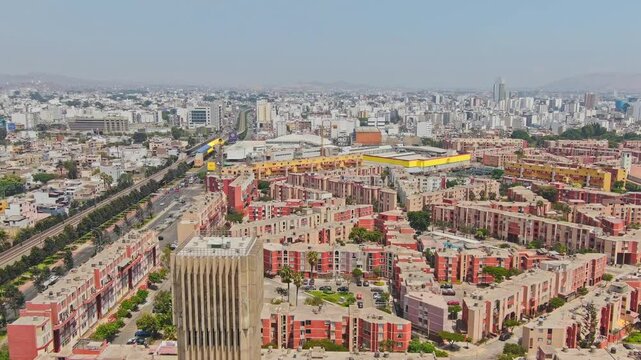 Aerial: Torres de Limatambo during the day with electric train and Aviation Avenue in San Borja District, Lima, Peru, Dolly Zoom, establishing drone shot