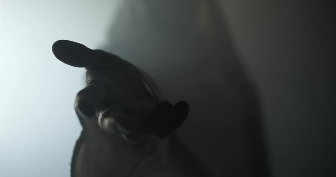 Closeup of Jesus Christ in glowing, ambient, light offering his hand for salvation, forgiveness. Cinematic visual representation of Easter resurrection, the gospel, and God's love and forgiveness.