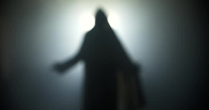Silhouette of resurrection of Jesus Christ inside the tomb, in bright light, raising his hands in dramatic, cinematic slow motion. Perfect for Christianity, Easter resurrection visual.