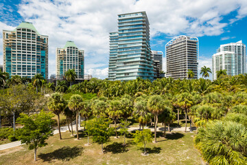 Coconut Grove, Miami, Florida - Feb 27, 2025: Elevated shot shows the lush canopy of Regatta Park beneath luxury condominiums, including twisting towers of Grove at Grand Bay.