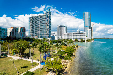 Miami, Florida: Feb 27, 2025 – Aerial photo showing Paramount Bay and Elysee towers in Miami behind Margaret Pace Park and Biscayne Bay on a sunny day.