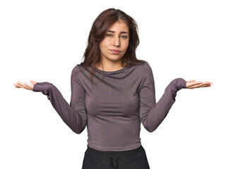Middle Eastern woman in studio doubting and shrugging shoulders in questioning gesture.