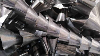 Steel scrap materials recycling. Aluminum chip waste after machining metal parts on a cnc lathe. Closeup twisted spiral steel shavings. Small roughness sharpness,