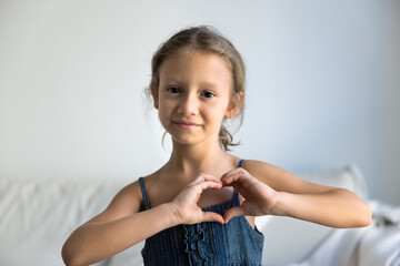 Sharing love with smile. Portrait happy preteen girl looking at camera making finger heart. Adopted child express love gratitude to foster parents. Little kid blogger appreciate audience for support