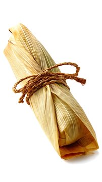 Brazilian pamonha wrapped in corn husk and tied with straw string, traditional food isolated on white background
