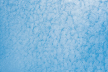 Sky filled with fluffy clouds reflecting a calm blue background