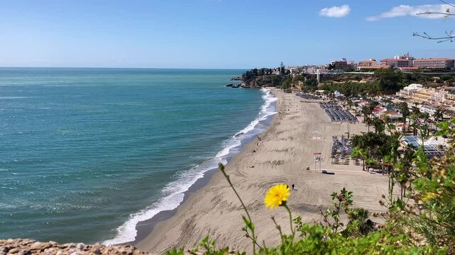 Wonderful landscapes of the shimmering sea and charming city unfold, offering breathtaking coastal views and a picturesque atmosphere in Nerja, Spain