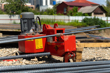 Hydraulic rebar bending machine bending steel bars at a construction site, preparing essential...