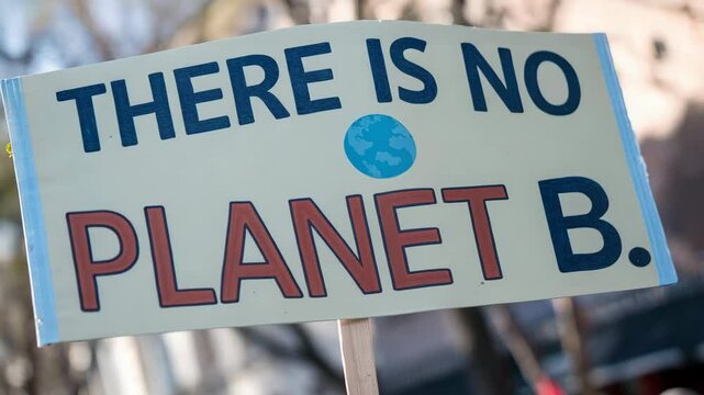 Climate action public awareness concept. A protest sign reads "There is no Planet B," emphasizing the urgency of addressing environmental issues for the future of Earth.
