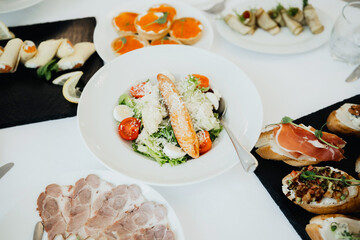 Salad with tomatoes and parmesan served at a buffet in a sunny location