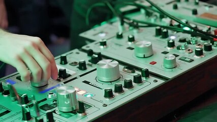 Close-up of hands adjusting vintage audio mixer