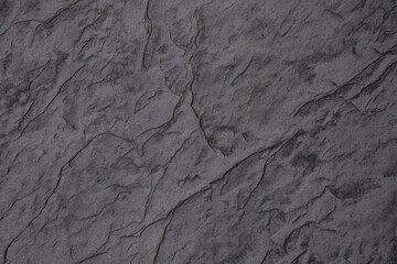 Textured gray stone surface with intricate patterns and details in natural light