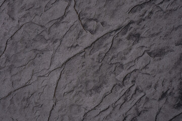 Textured dark stone surface with natural patterns and grooves