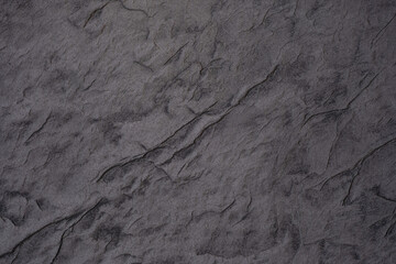 Surface texture resembling dark stone with subtle variations and patterns
