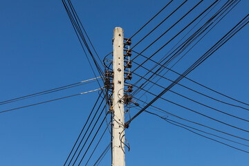 power lines and communication lines on electric poles with the blue sky