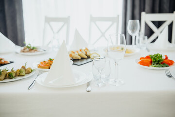 Dining table arranged with various dishes and glassware in a bright setting