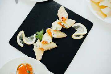 Deliciously plated sushi rolls with lemon slices on a black serving board