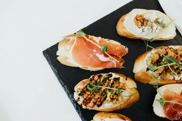 Delicious appetizers served on a black slate platter at a gathering
