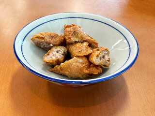 traditional asian deep fried crispy golden chicken wu xiang meat vege roll appetiser in white bowl...
