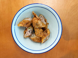 traditional asian deep fried crispy golden chicken wu xiang meat vege roll appetiser in white bowl...