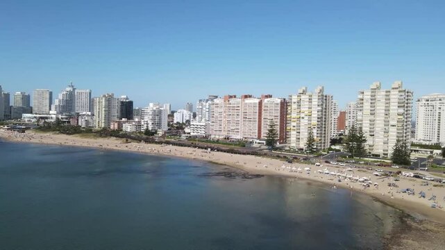 Tourists relaxing on playa mansa beach in punta del este, uruguay, enjoying a beautiful sunny day