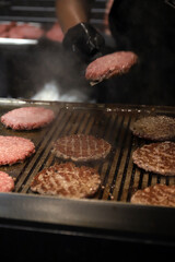 chef friendo hamburguesas de carne a la parrilla