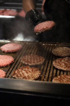 chef friendo hamburguesas de carne a la parrilla