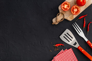Picnic flatlay. Steel barbecue utensils with tomatoes and greens, top view