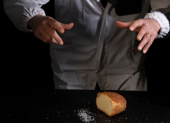 Salting bread on black background, concept