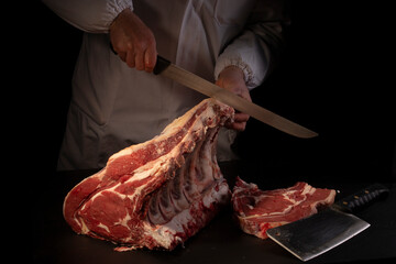 Butcher cutting loin on black background