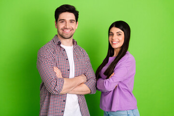 Happy young couple posing confidently against a green background, representing friendship, love, and casual lifestyle concepts