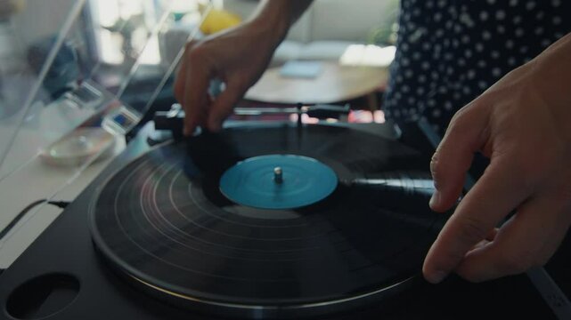 Dj playing vinyl record on turntable at home