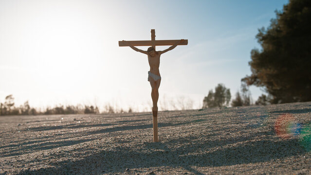Chist Crucifix In The Sand With Sunlight