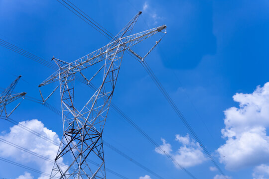 High voltage electric pole on blue sky in sunlight