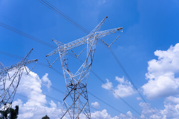 High voltage electric pole on blue sky in sunlight