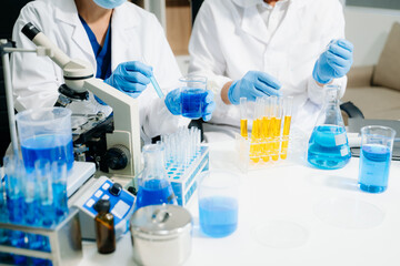 Two  scientists in a high-tech lab analyzing biochemical samples, using micro pipettes