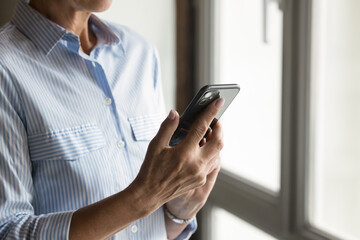 Close up of hands of mid-aged busy influential businesswoman using her smartphone for e-commerce transaction, staying connected, focus on success, efficiency, modern business, smart services concept