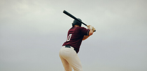 Baseball player poised to hit the pitch, showing concentration and readiness at the batter's box